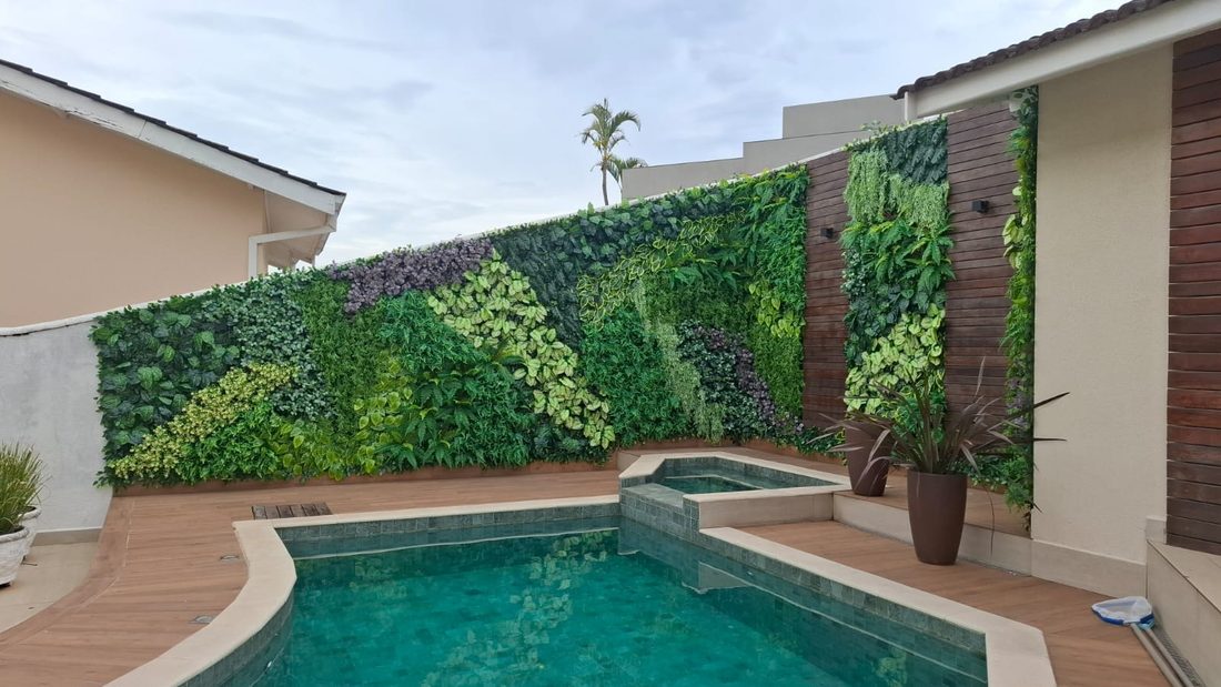 Área de piscina com jardim vertical artificial e vista da cidade