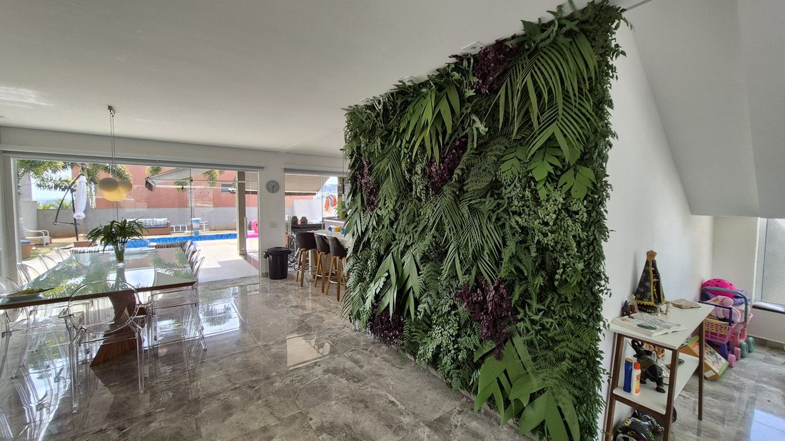 Área de lazer externa com parede de plantas artificiais