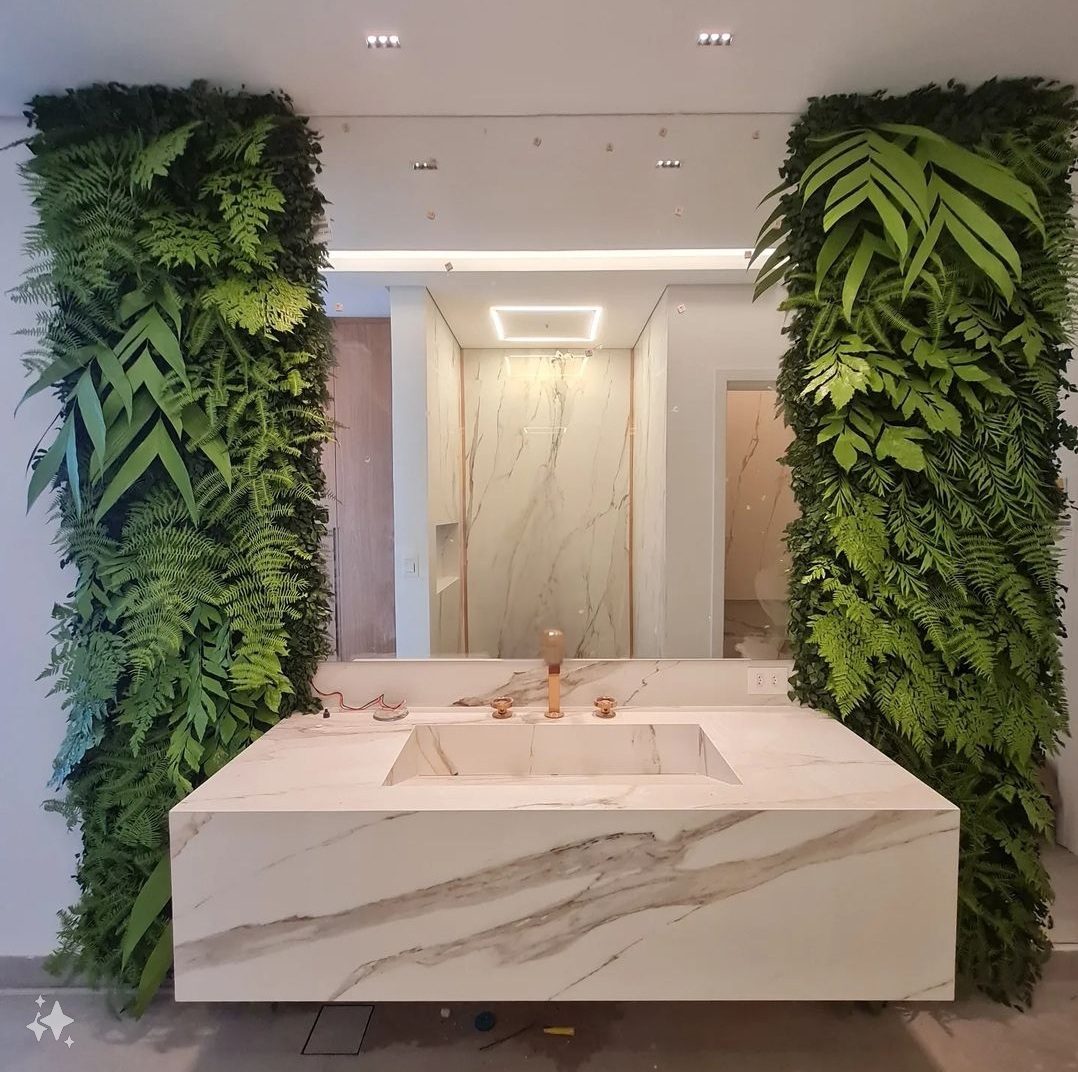 Banheiro com parede de plantas artificiais e bancada de mármore