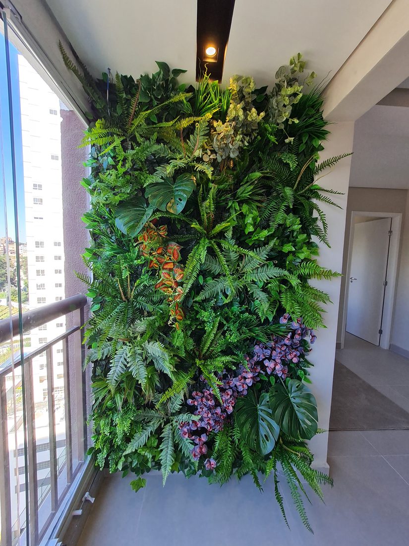 Varanda de apartamento com jardim vertical artificial e vista da cidade