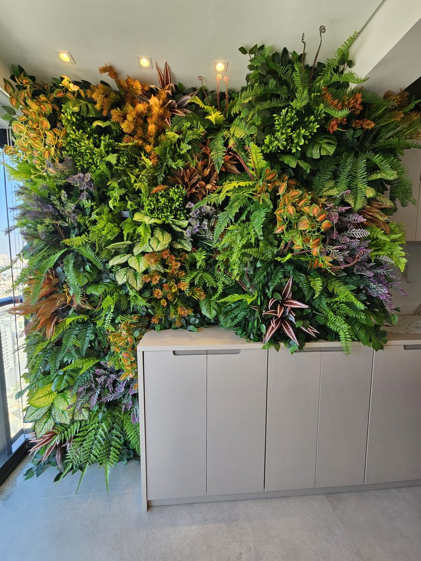 Varanda com jardim vertical artificial em tons variados de verde