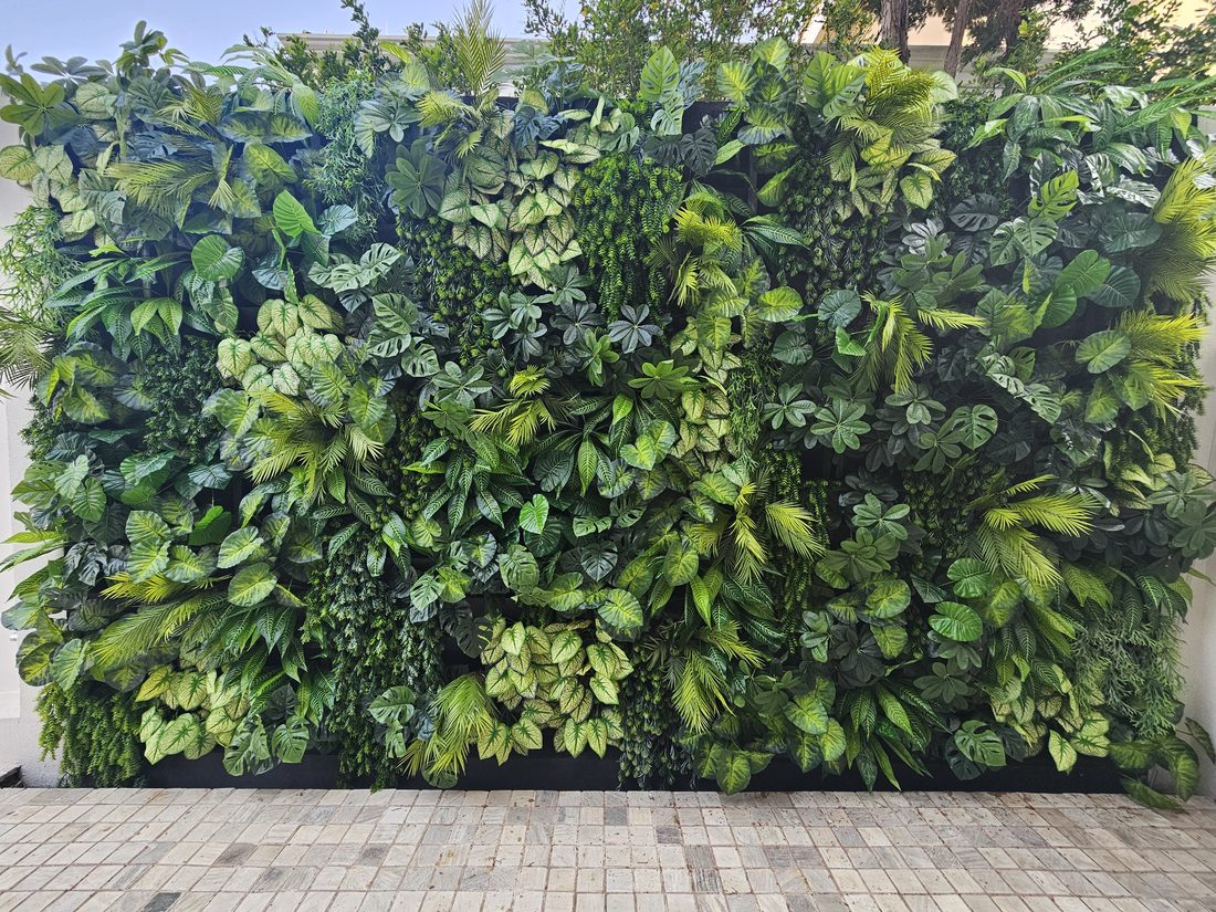 Quintal com painel amplo de plantas artificiais