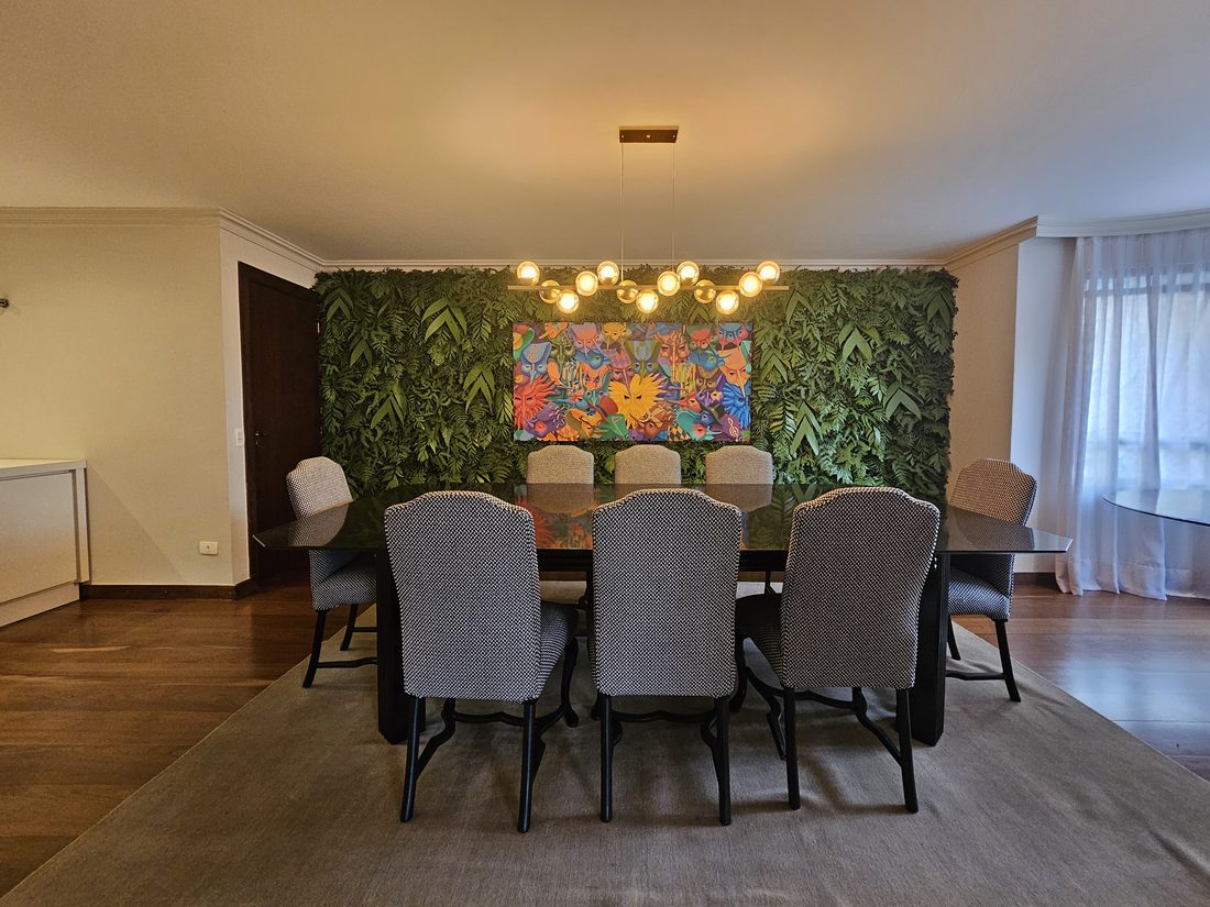 Sala de jantar com parede de plantas artificiais