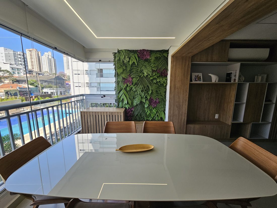 Sala de jantar com varanda e jardim vertical artificial com vista