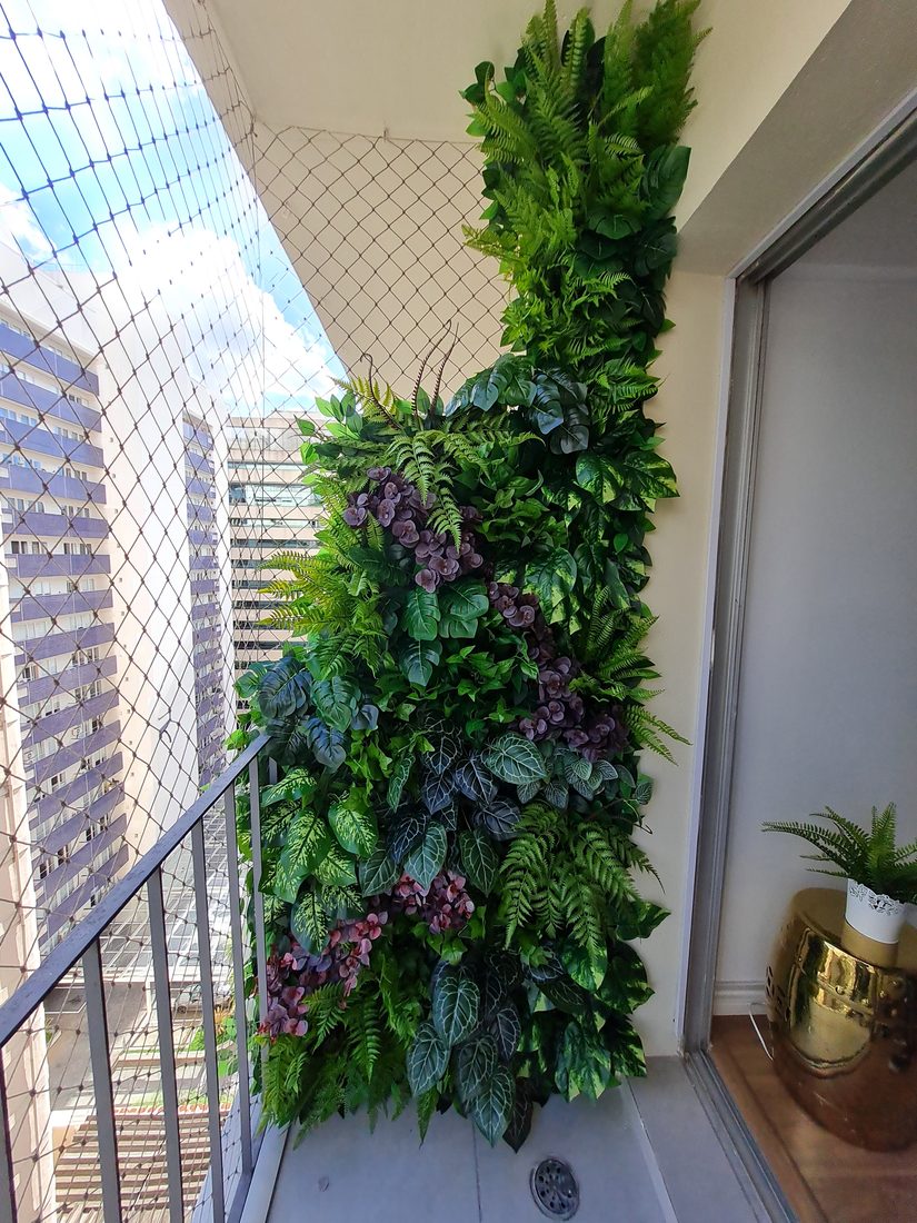Varanda com jardim vertical artificial e tela de proteção