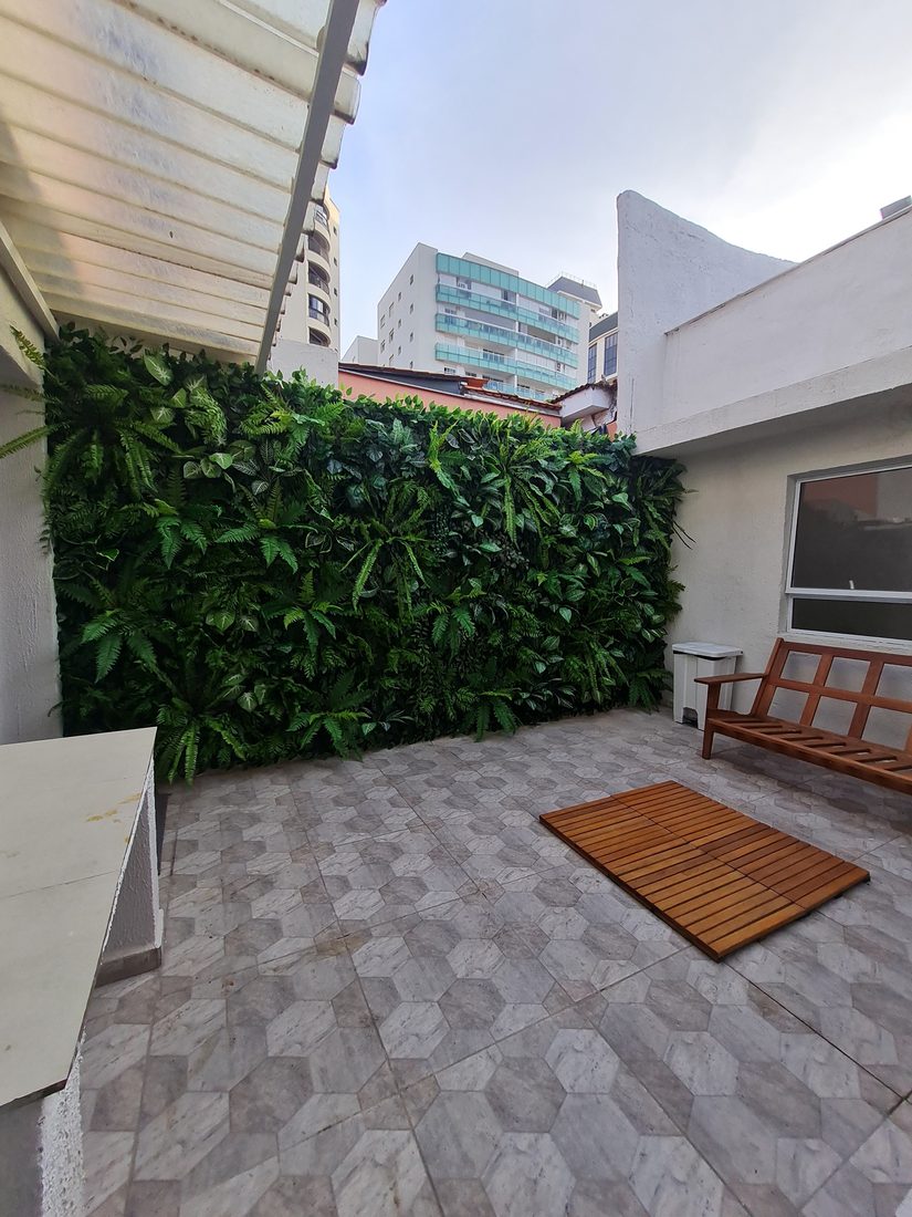Terraço com jardim vertical artificial e banco